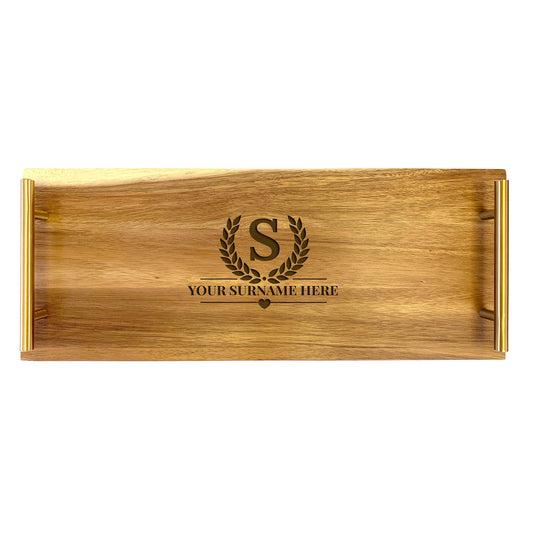A large serving tray made from acacia wood with a laurel wreath design and a placeholder for a custom name.