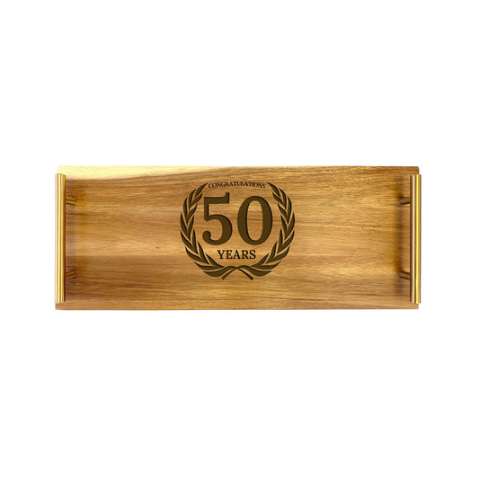 A small acacia wood serving tray with '50 years' engraved on it.