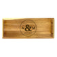 A wooden serving tray with circle initials engraved on it, indicating a personalized touch.