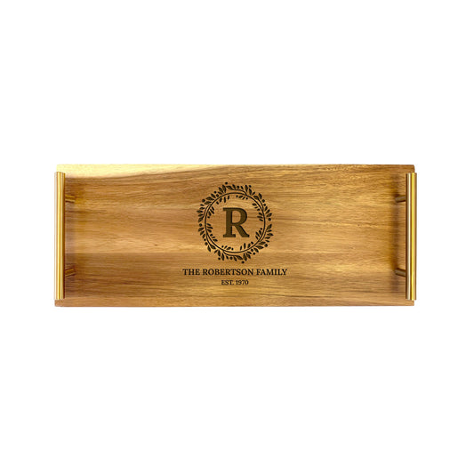 A small wooden serving tray with a laser-engraved monogram initial 'R' in the center, surrounded by a floral design, and the text 'THE ROBERTSON FAMILY EST 2019'.