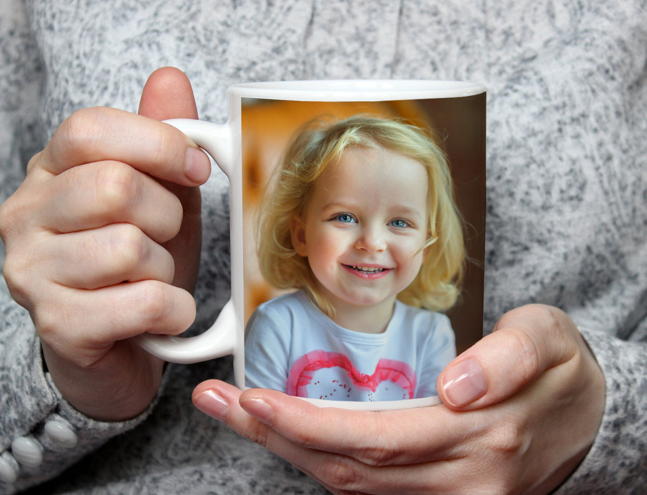 mother holding a custom photo mug which is customised with image of kid