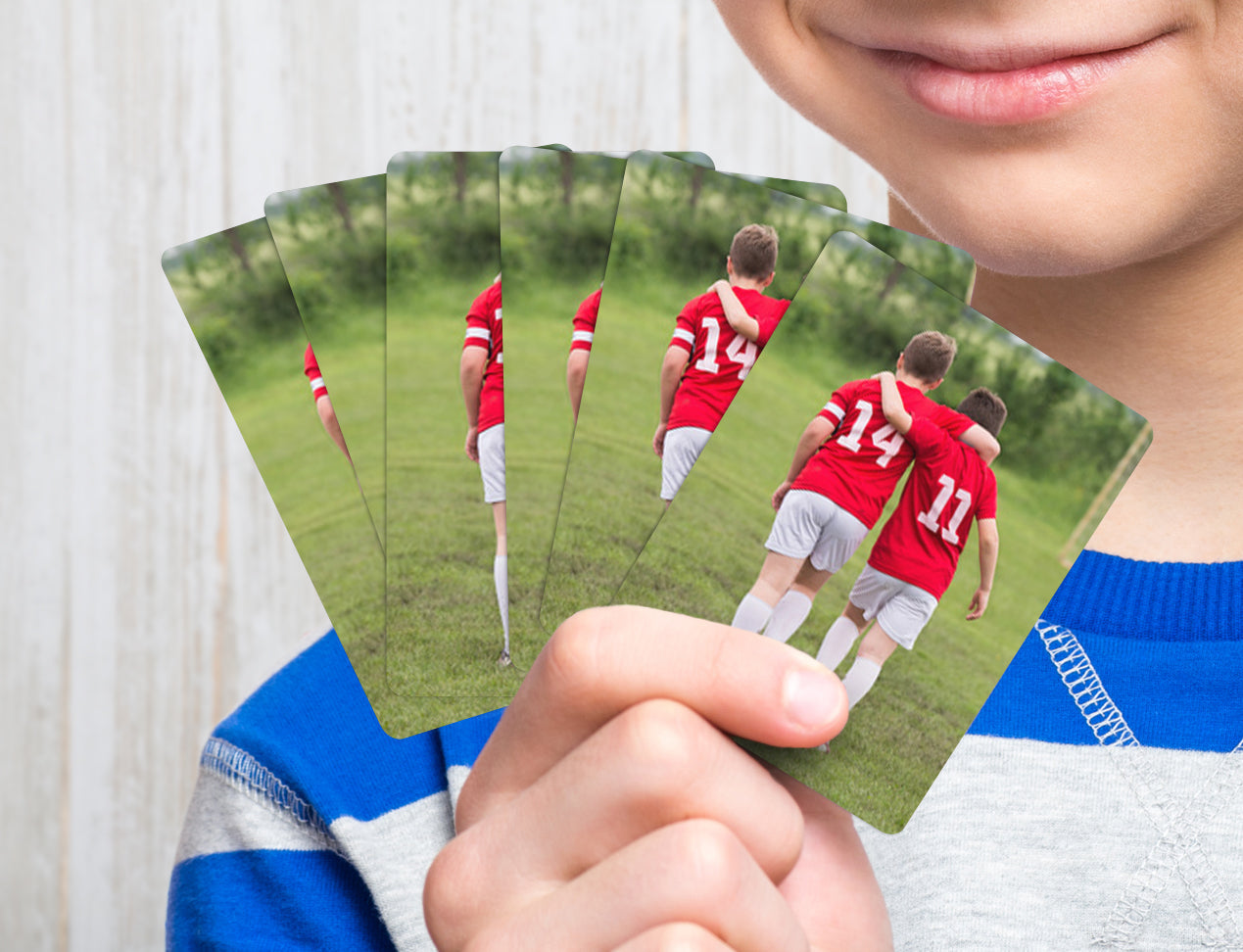 custom playing cards deck customised with team photo on the backside held by kid